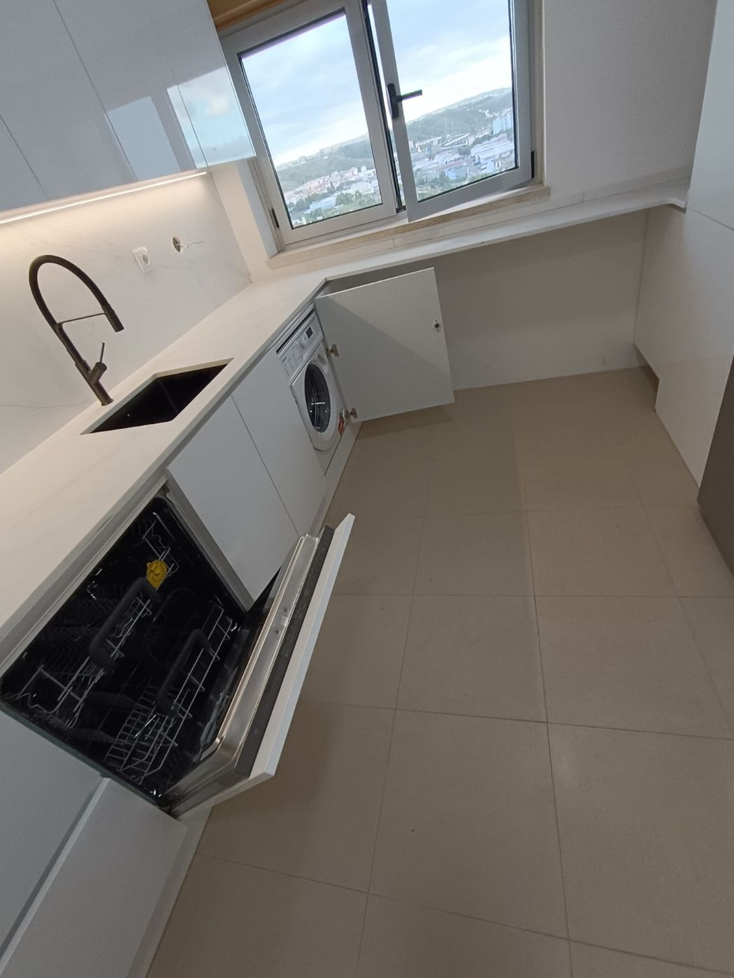 Cozinha branca de canto com máquina de loiça