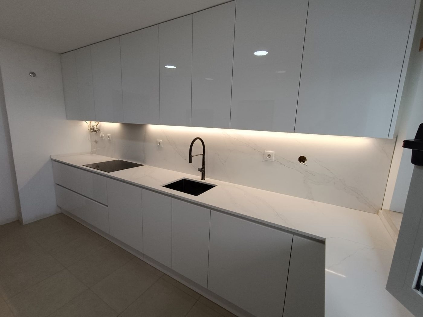 Cozinha branca com iluminação LED sob armários